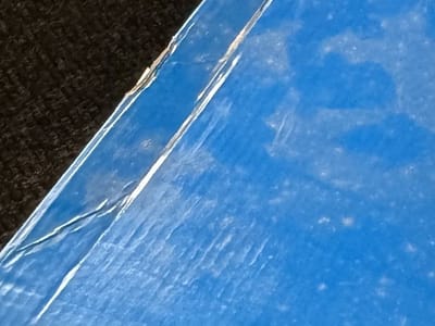 Before: pale mould bloom across a printed shoe box lid