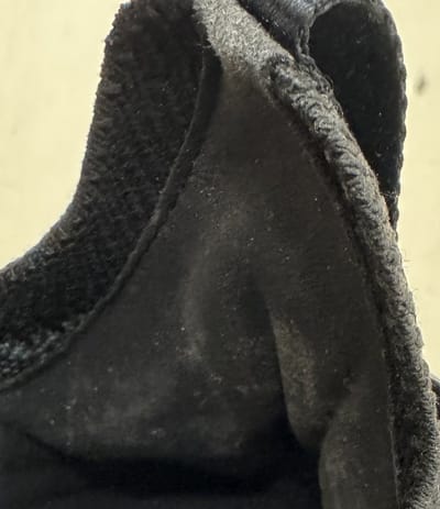 Before: grey mould bloom across the black inner heel lining of a knit trainer